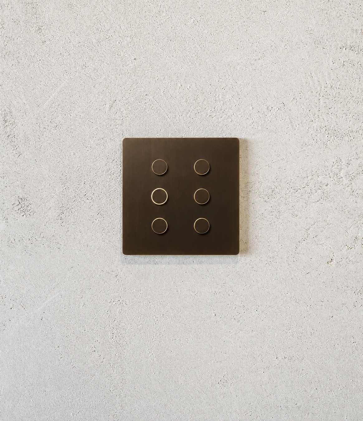 Alisse de seis botones en bronce sobre una pared de yeso claro