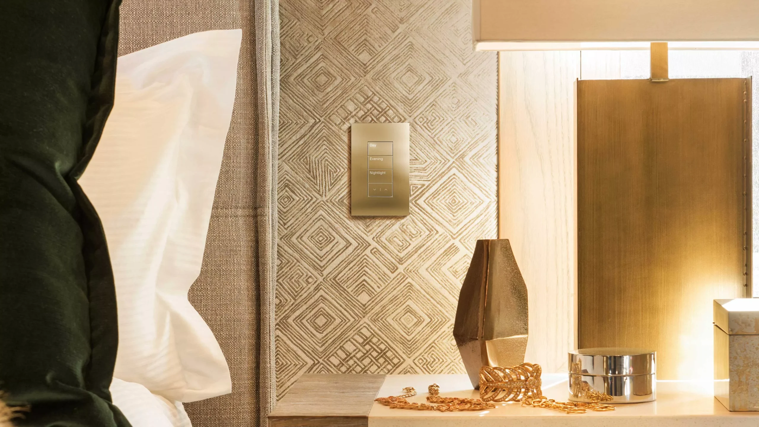 Palladiom en latón instalado sobre un revestimiento textil junto a una cama