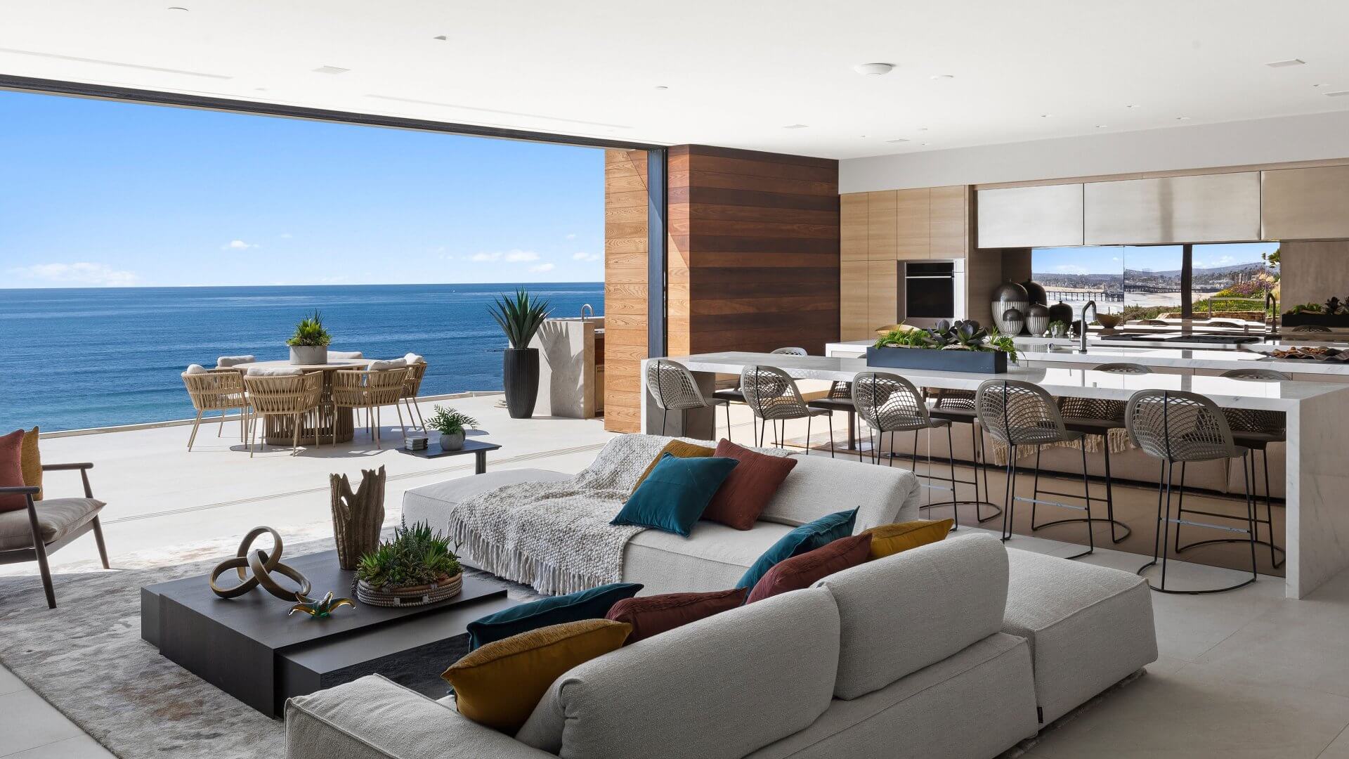 Living de Ora House abierto a la terraza y al océano Pacífico